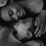 Mãos segurando as de uma mãe em luto, transmitindo apoio e empatia após a perda de um filho adulto.