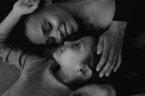 Mãos segurando as de uma mãe em luto, transmitindo apoio e empatia após a perda de um filho adulto.